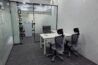 Modern private office workspace with ergonomic chairs, white desks, glass partition meeting room, and air-conditioned environment at Universe Coworks.
